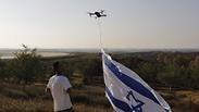 צעיר מטיס רחפן עם דגל ישראל ליד גבול ישראל ועזה