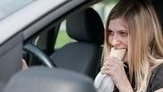 אישה אוכלת באוטו