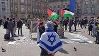 יהודי באמסטרדם שמפגין לבדו עם דגל ישראל ענק מול הפגנות הסתה של ה- BDS