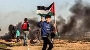 פלסטינים מפגינים מול גדר המערכת