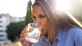 אישה שותה מים עם לימון