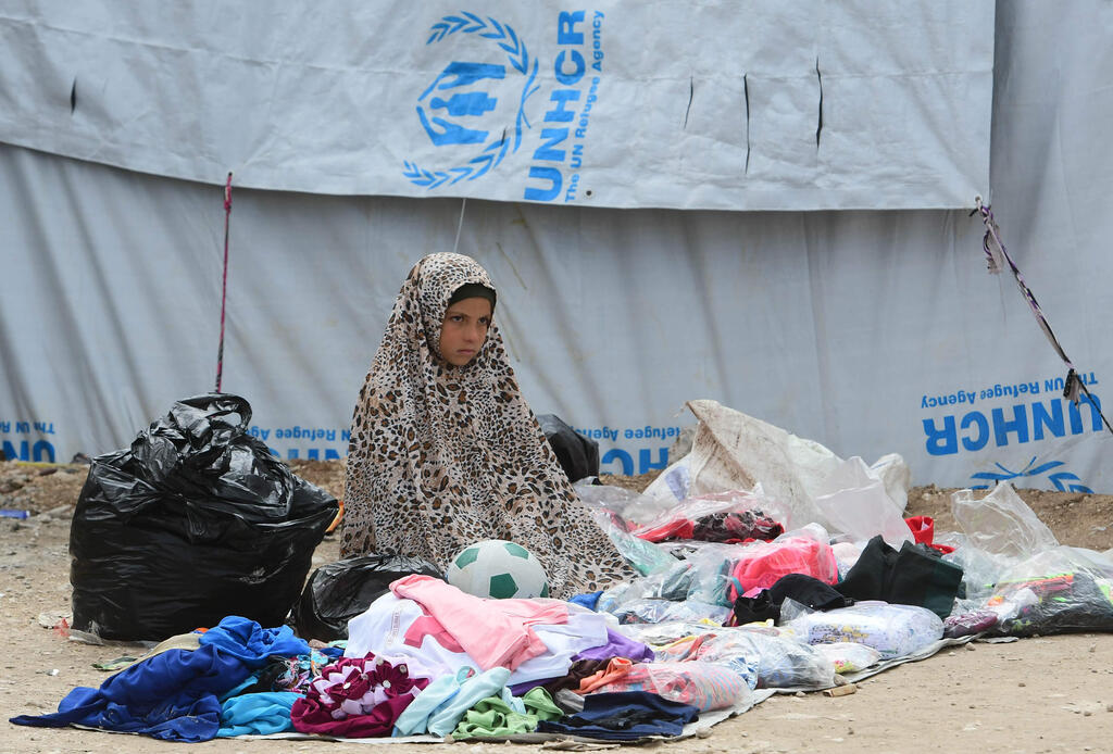 A Syrian girl sells second hand items in the Al-Hol camp for displaced people in northeastern Syria on March 28, 2019 