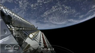 60 הלוויינים לפני השחרור, מצולמים מתוך הפאלקון. ברקע כדור הארץ. 