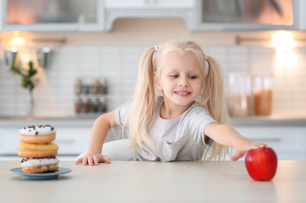 ילדה בוחרת במזון בריא ולא בממתקים