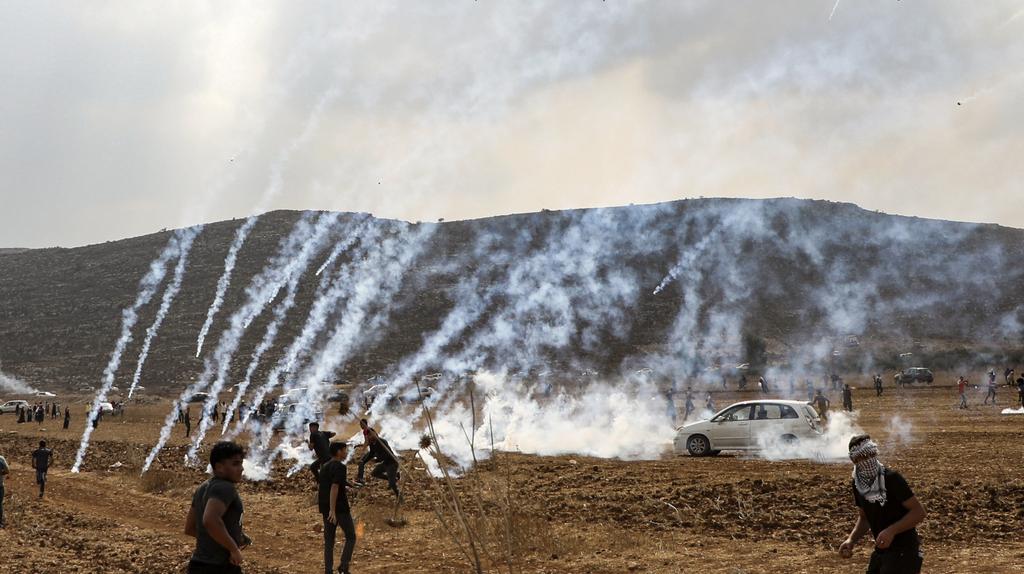 Tear gas fired by IDF troops falls among Palestinians protesting the construction of an outpost near the West Bank settlement of Shiloh, Oct. 17, 2019