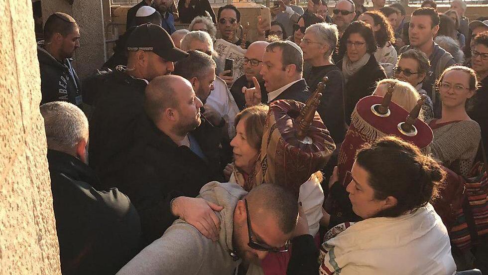 Police and ultra-Orthodox worshippers prevent members of the Women of the Wall organization from praying with Torah scrolls at the Western Wall 
