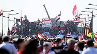 עיראק מפגינים עומדים על מחסומים שהקים הצבא בגדד