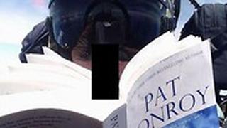 טייס חיל הנחתים של ארה"ב קורא ספר ב טיסה יפן