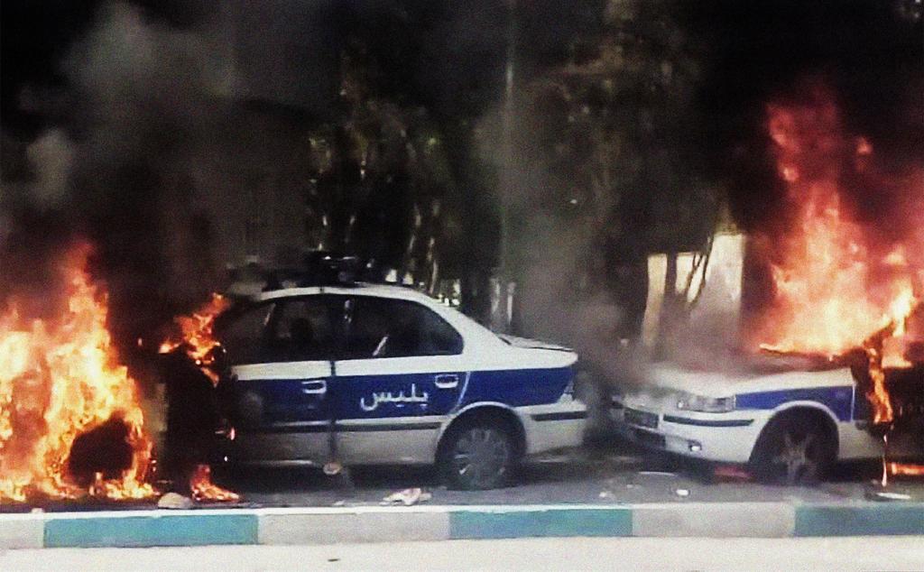 Iranian protesters set fire to police cars during a demonstration against an increase in gasoline prices in Tehran, Nov. 16, 2019