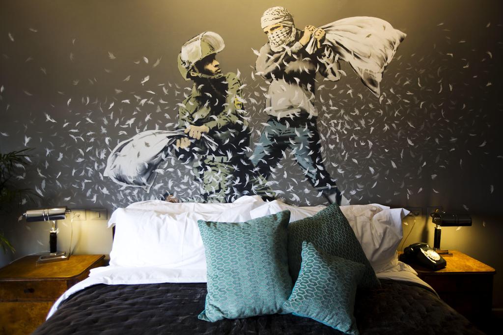 A Banksy wall painting of an Israeli Border Police officer and a Palestinian in a pillow fight dercorates one of the rooms of the The Walled Off Hotel in the West Bank city of Bethlehem 