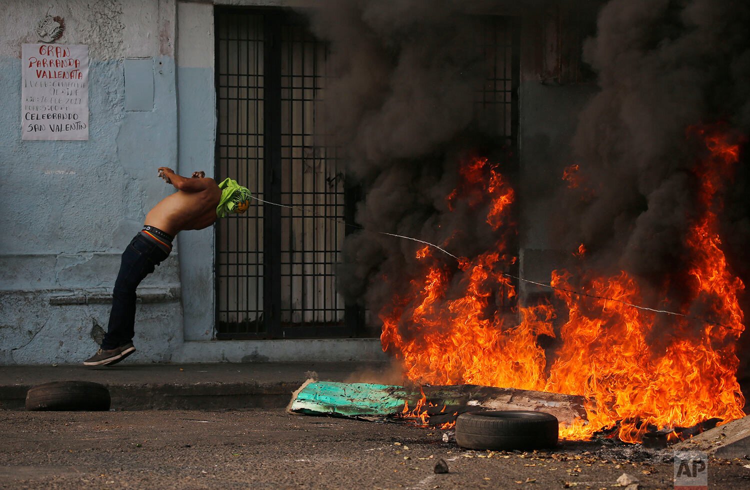 A demonstrator is knocked over by a strand of barbed wire during clashes with the Bolivarian National Guard in Urena, Venezuela, near the border with Colombia 
