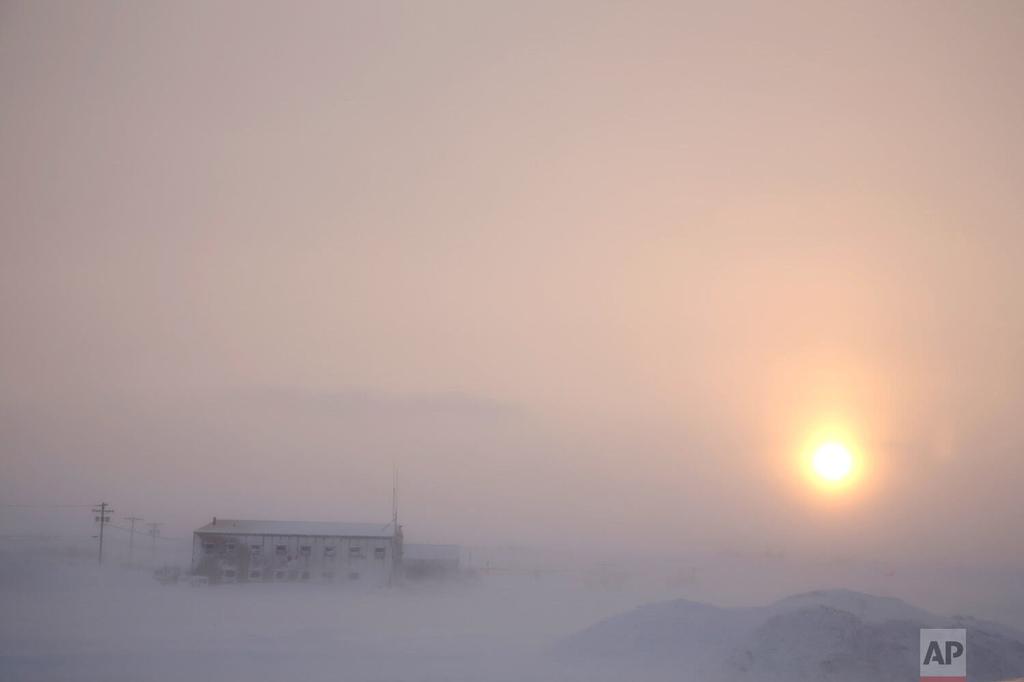 The afternoon sun hangs low as it shines through the snow at the airport in Nome, Alaska 