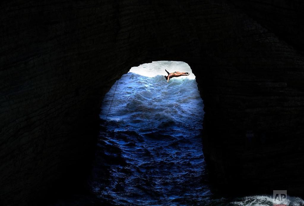 A cliff diver jumps from the landmark Raouche sea rock during qualifying for the Red Bull Cliff Diving World Series competition in Beirut, Lebanon 