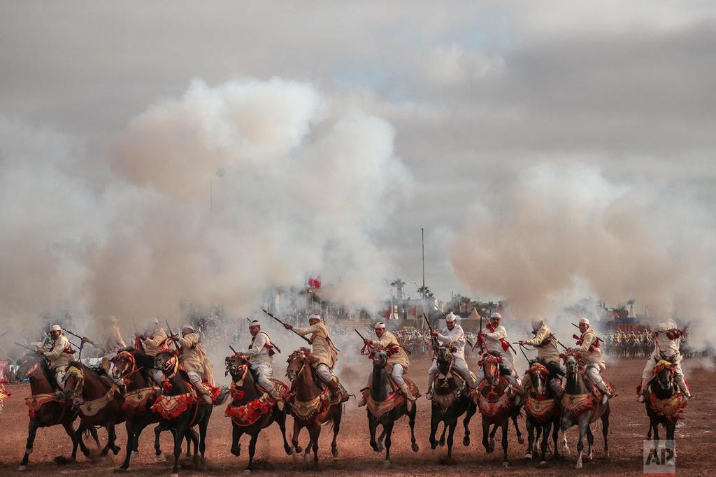 A troupe charges and fires their rifles during Tabourida, a traditional horse riding show also known as Fantasia, in the coastal town of El Jadida, Morocco 