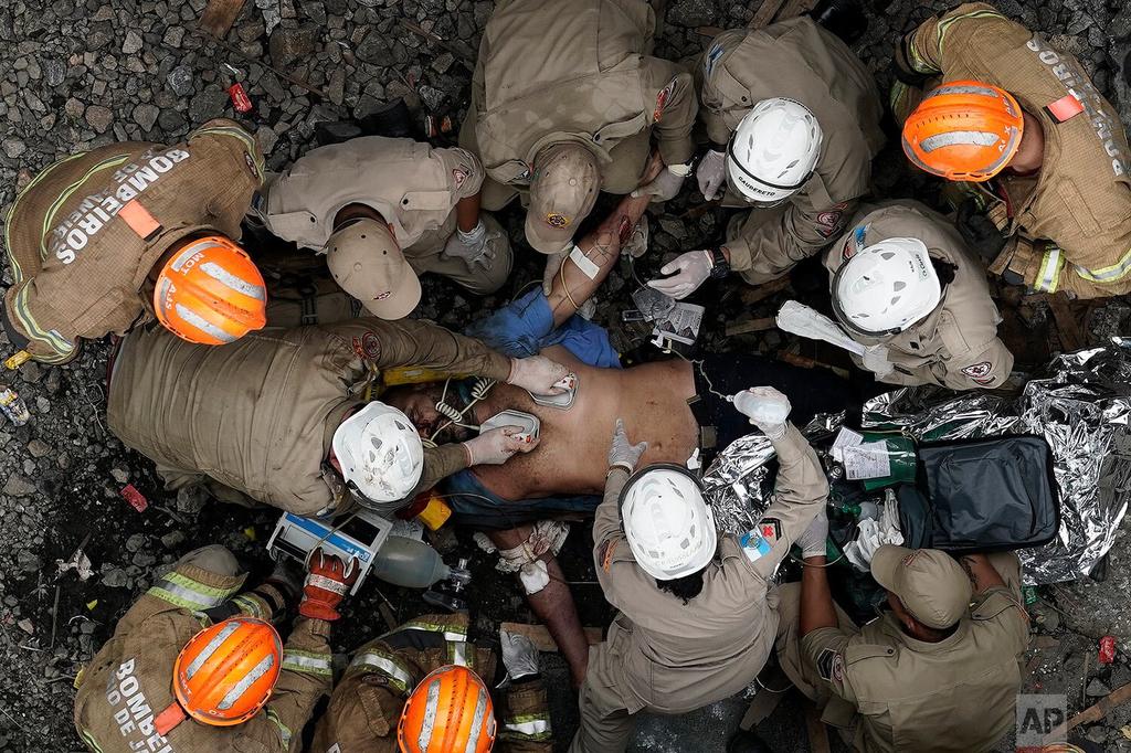 Firefighters work to resuscitate the driver of a commuter train who was injured in a collision with another train in Sao Cristovao station in Rio de Janeiro, Brazil 