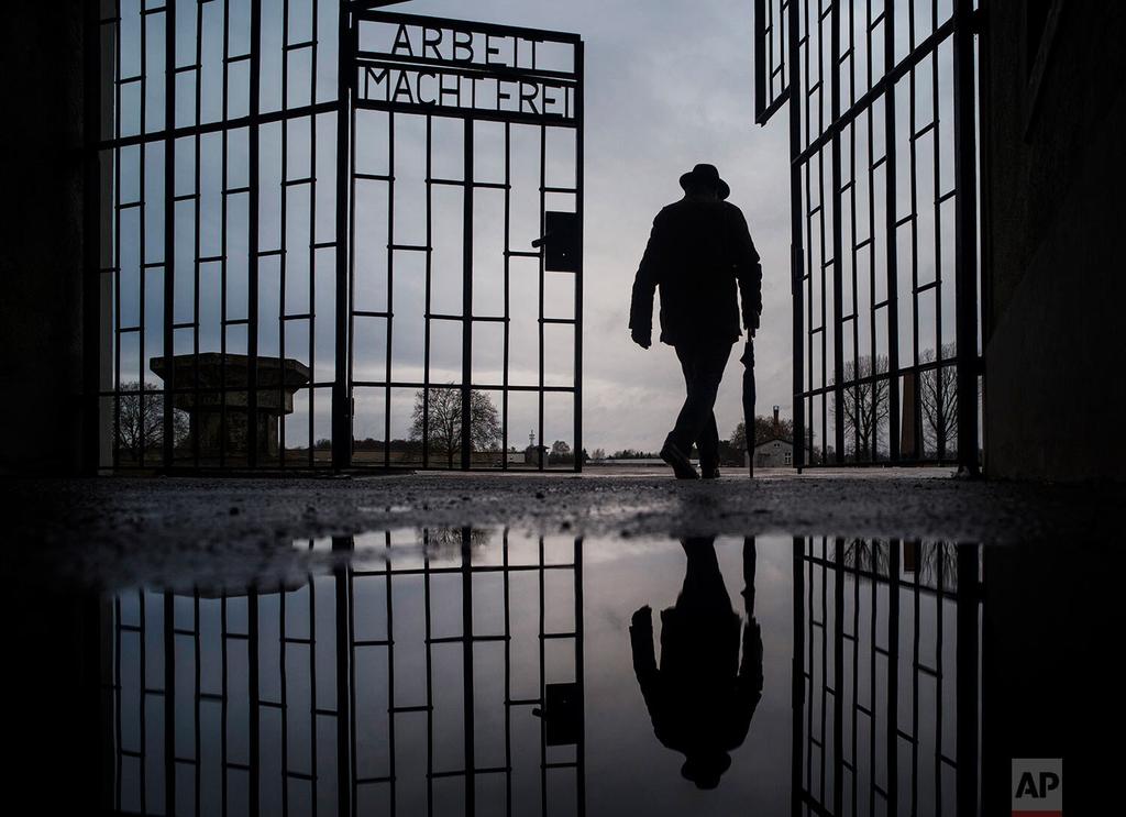 A man walks through the gate of the Sachsenhausen Nazi death camp with the phrase "Arbeit macht frei" (work sets you free) in Oranienburg, Germany, on International Holocaust Remembrance Day 