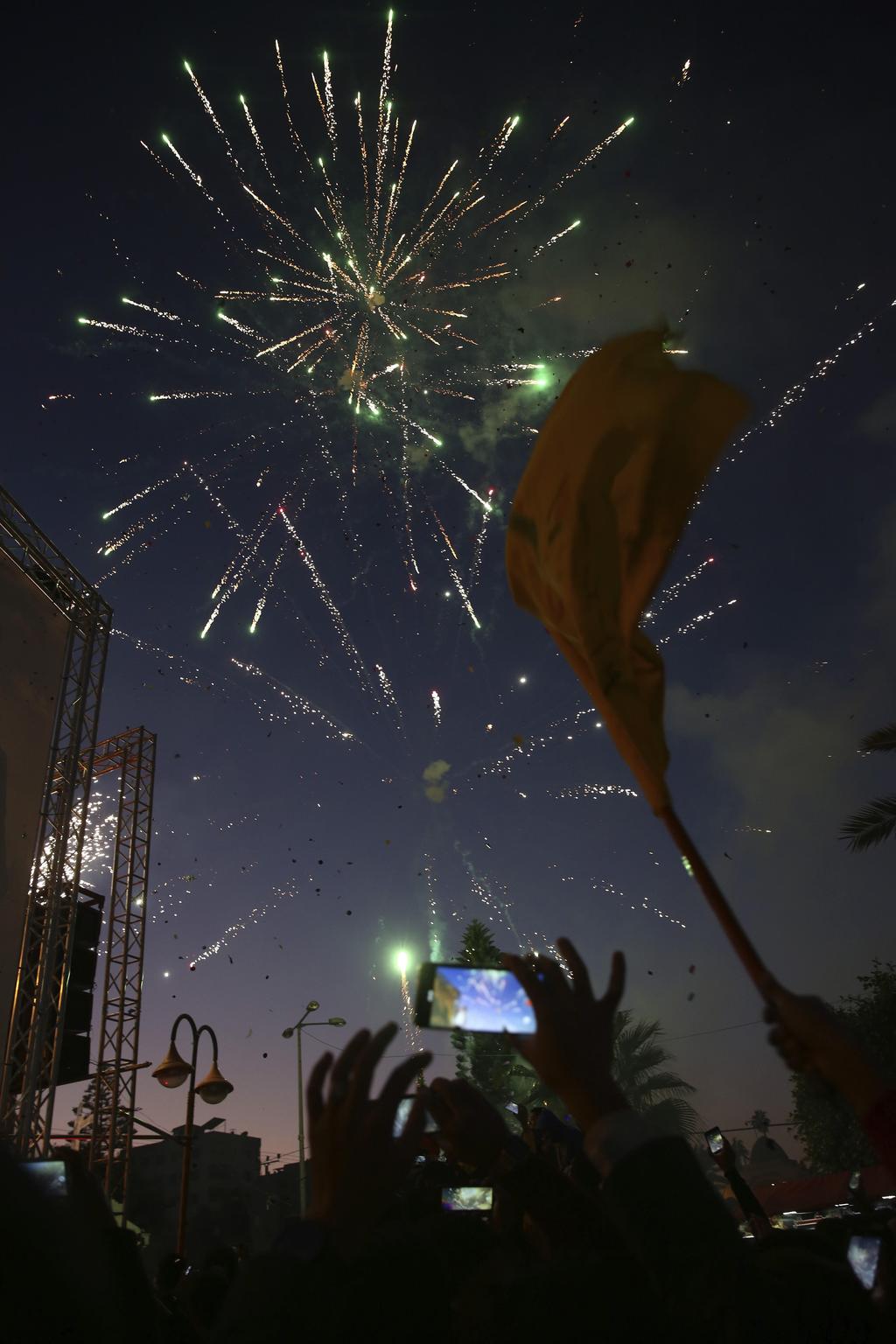 Palestinians take photos of fireworks during a celebration marking the 55th anniversary of the Fatah movement in Gaza City, Dec. 31, 2019
