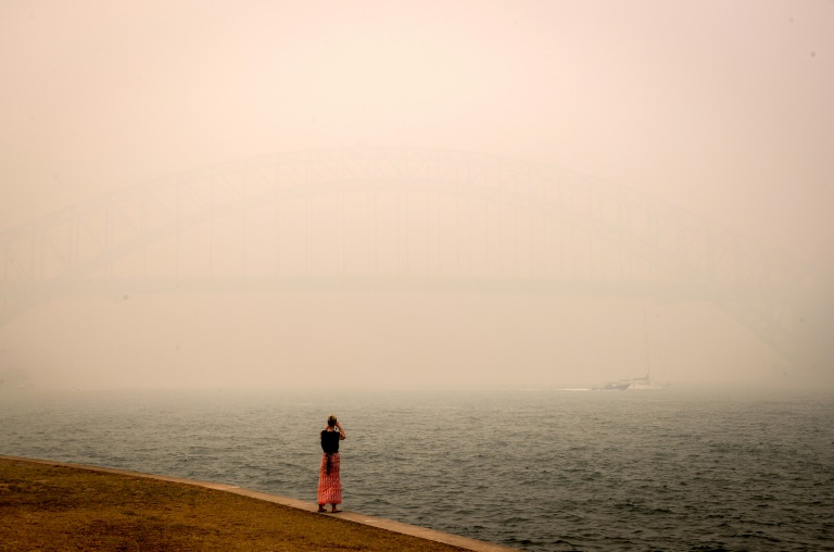 The barely visible Sydney Harbour Bridge is enveloped in haze caused by nearby bushfires