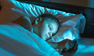 ילד מתכונן לשינה עם טלפון חכם