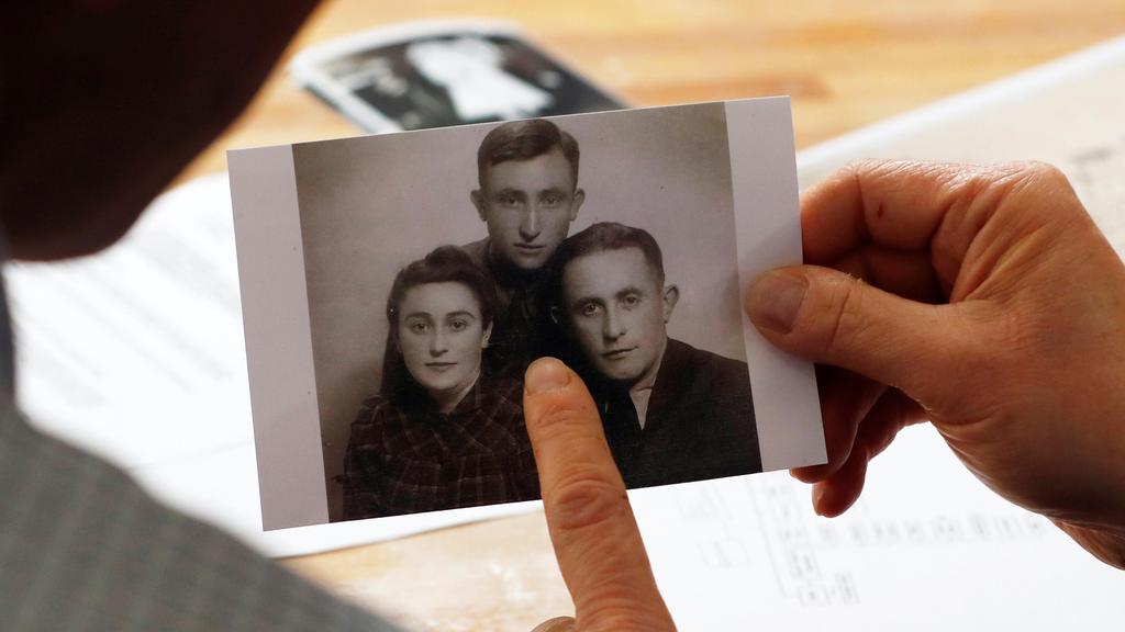 Eli and Saul Lieberman show a photograph of their late father Joseph (top), a survivor of the Nazi death camp Auschwitz, taken several years after the Holocaust 