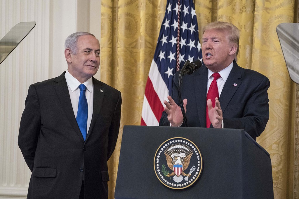 Benjamin Netanyahu stands beside Donald Trump as he unveils his Mideast peace plan at the White House, January 2020 