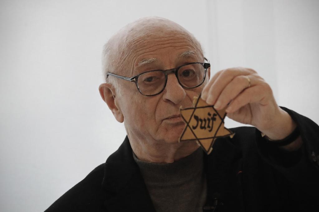 Victor Perahia, who survived the Holocaust as a child, shows a yellow star worn by Jews in Nazi-occupied areas during a workshop at the Drancy Shoah memorial, Jan. 30, 2020 
