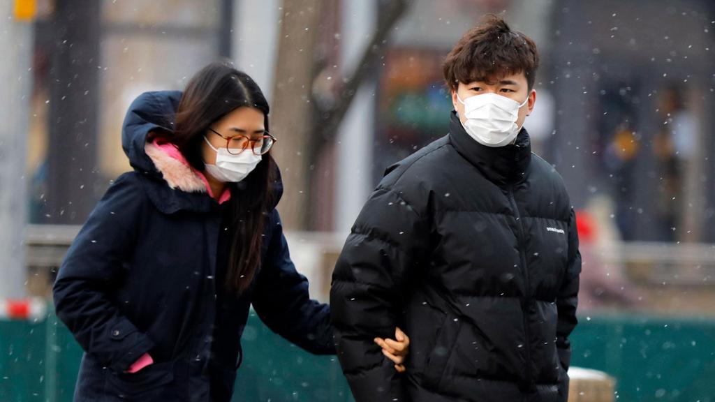 נגיף וירוס קורונה אנשים לובשים מסכות ההולכות ברחוב בבייג'ינג, סין