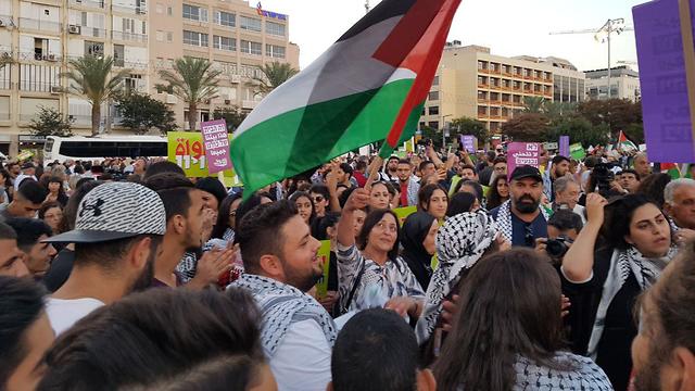 Protesters wave a Palestinian flag during a 2018 demonstration in Tel Aviv's Rabin Square 