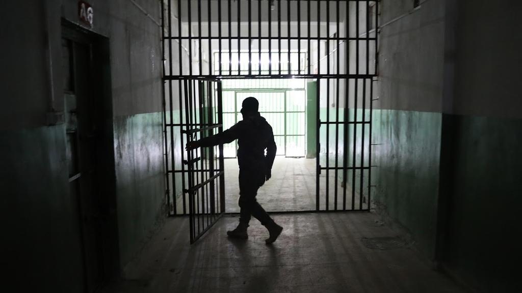 A guard opens a door inside a prison that holds foreign prisoners, suspected of being part of the Islamic State, in Hasaka 