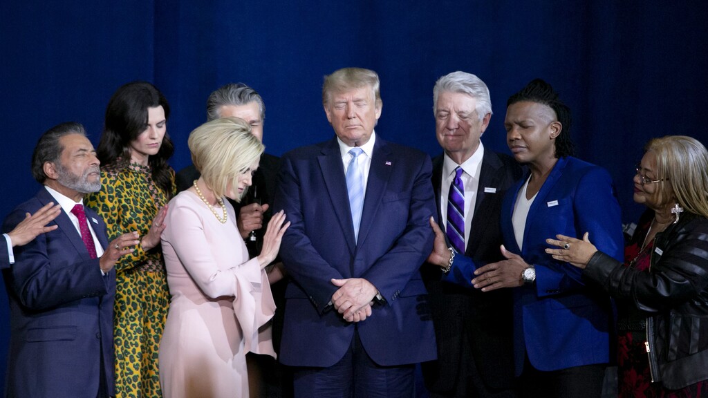 Donald Trump praying in a rally for evangelical voters 