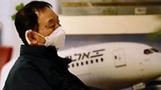 תייר עם מסכה ב נתב"ג מחכה ל טיסה חזרה ל דרום קוריאה נגיף קורונה