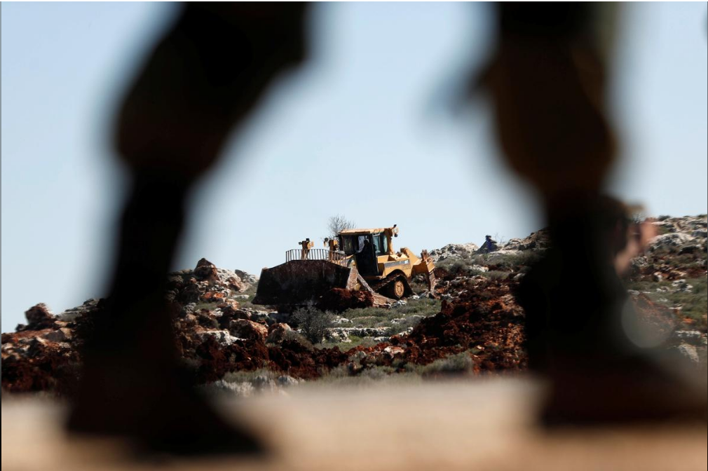 Israeli machinery, guarded by IDF forces, bulldozes lands near the Palestinian village of Qusra 