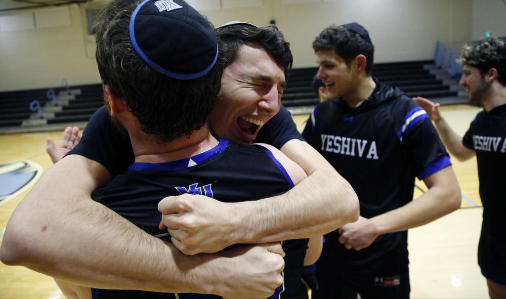 Yeshiva forward Michael Bixon hugs forward Daniel Katz, back to camera, after the team's 102-83 win over Penn State-Harrisburg