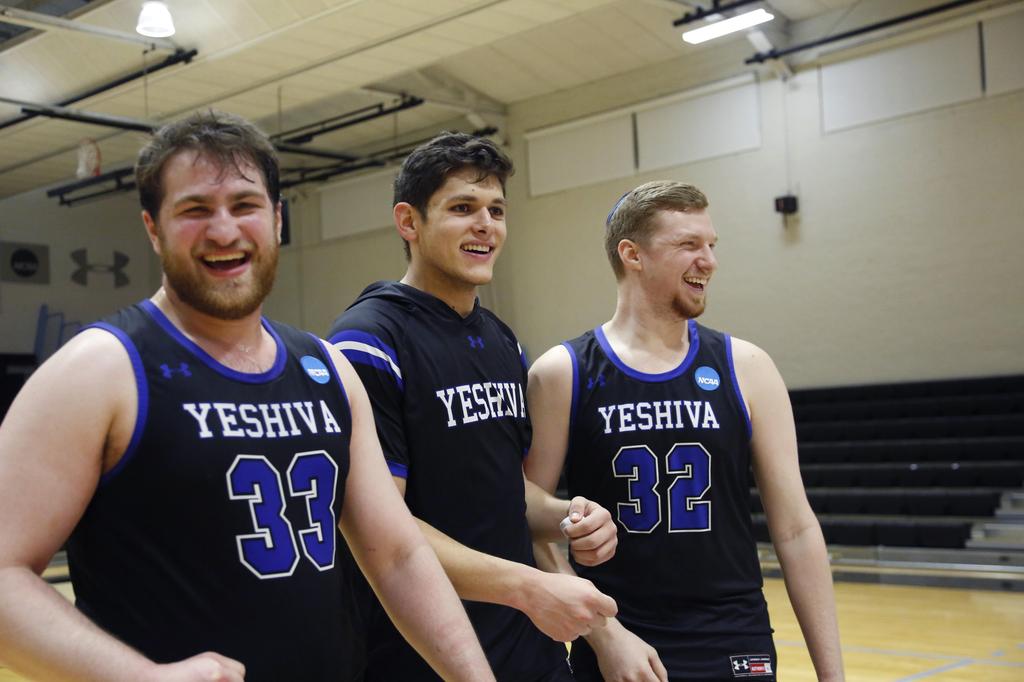 Yeshiva seniors and forwards Daniel Katz (33), Gabriel Leifer and Kevin Bokor (32) celebrate the team's 102-83 victory over Penn State-Harrisburg