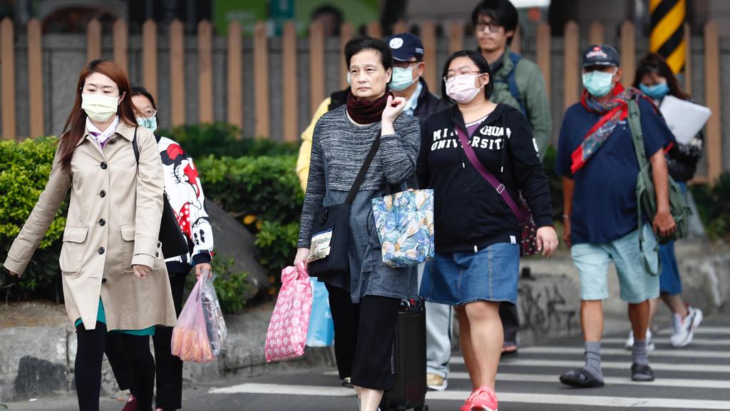 Taiwanese people wearing masks as a precautionary measure walk in the street, in Taipei 