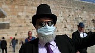 איש אם מסכת פנים בגלל הקורונה בכותל המערבי בירושלים