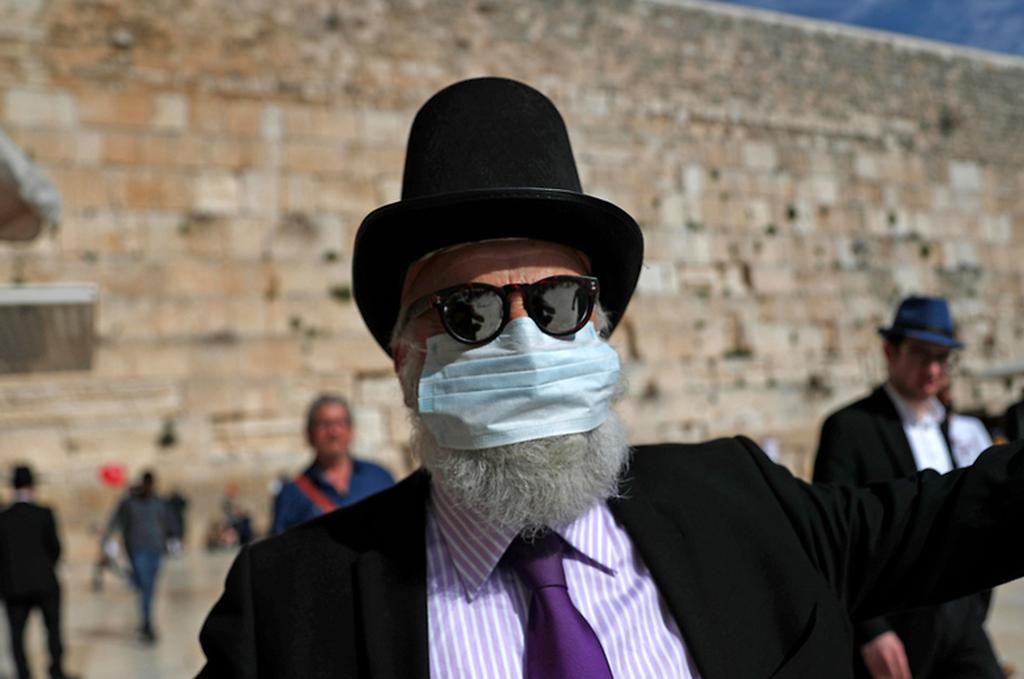 איש אם מסכת פנים בגלל הקורונה בכותל המערבי בירושלים