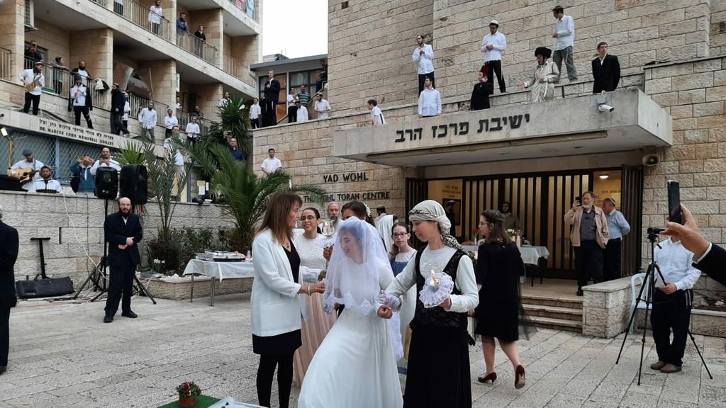 An ultra-Orthodox wedding is held at a Jerusalem yeshiva, with celebrants observing the directives to  keep their distance