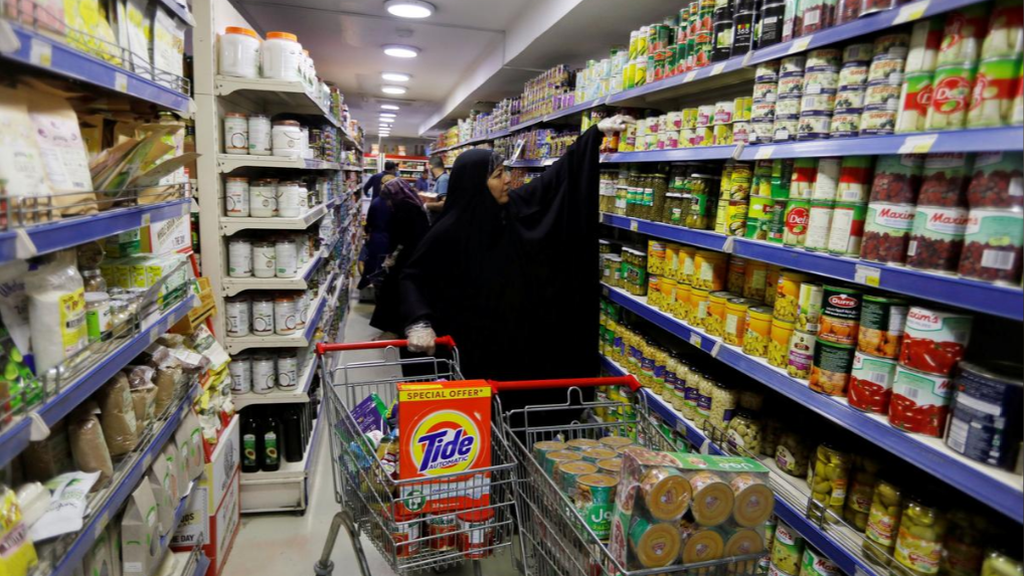 A woan wearing gloves, as she's buying last-minute groceries before curfew in Baghdad, Iraq 