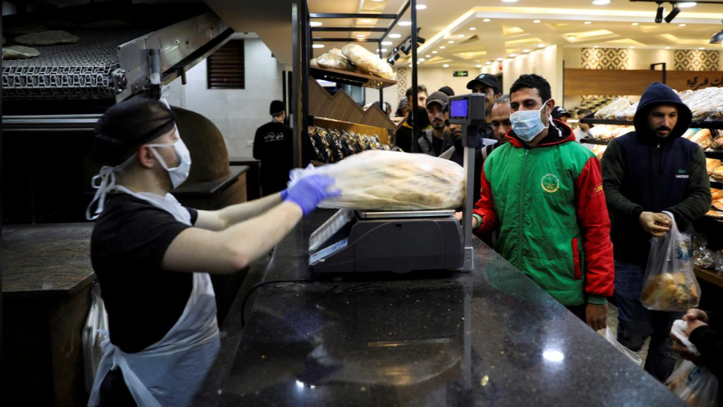 People stand in line at a bakery in Amman, Jordan amid growing fearsover coronavirus 