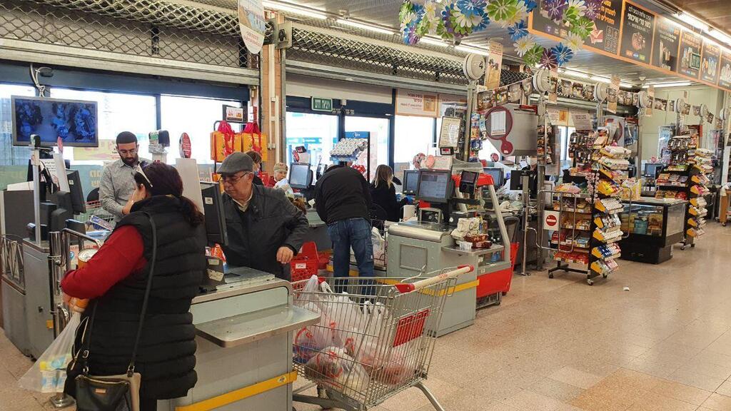 Customers attempt to maintain social distancing while shopping at a Shufrasal store in Sderot 