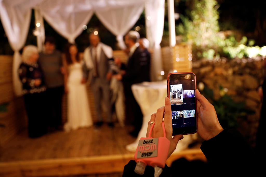 A woman uses a video conferencing app to share the wedding of Roni   Ben-Ari and Yonatan Meushar at Ein Hemed Forest Wedding Venue, March 18, 2020