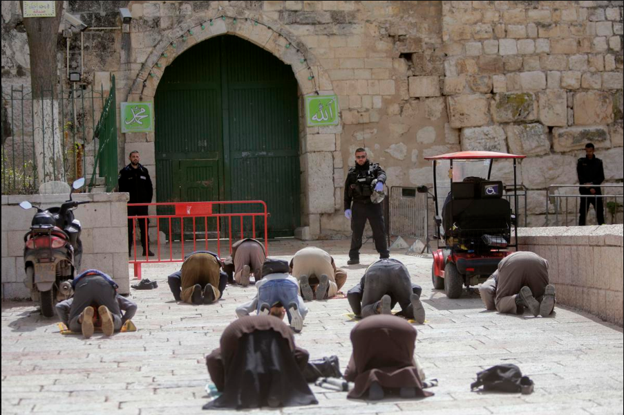 Muslims praying outside the shuttered gates of the Al-Aqsa Mosque 