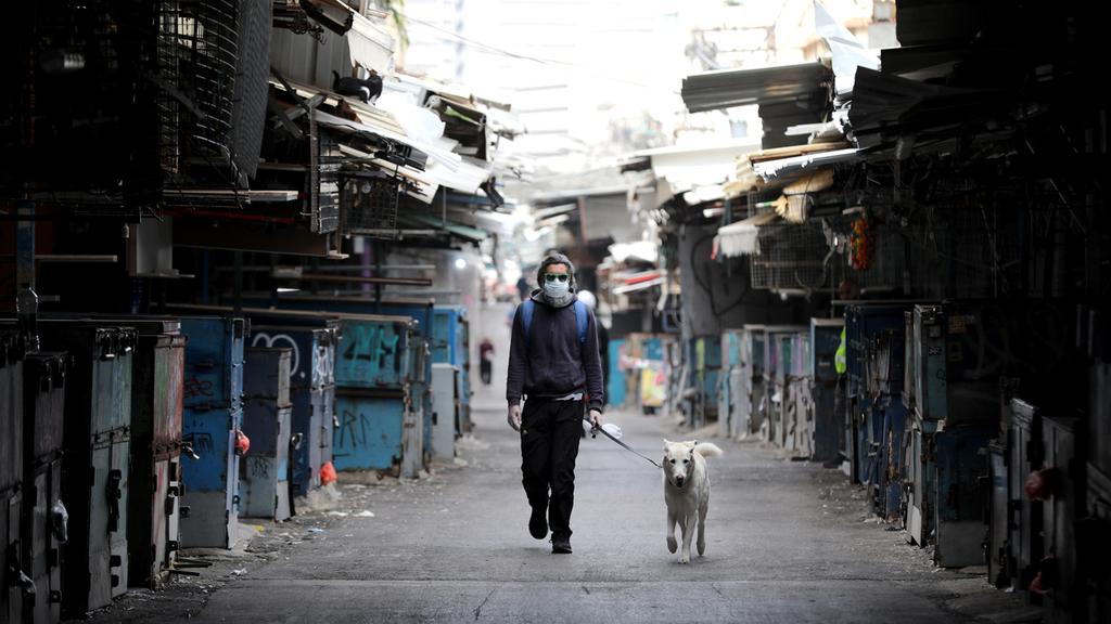 A man walks with his dog through the shuttered Carmel market in Tel Aviv 