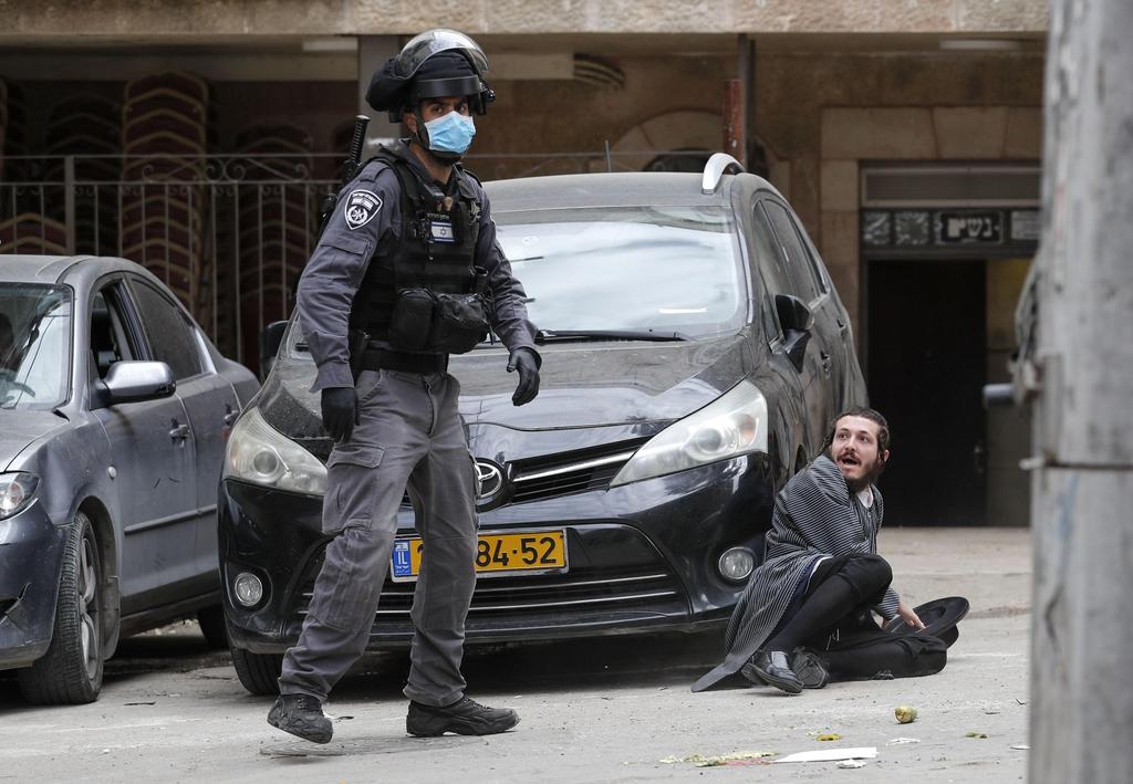 Israeli security forces arrest an Ultra Orthodox Jewish man as they close a synagogue in the Mea Shearim Ultra-Orthodox neighbourhood in Jerusalem, amid efforts to curb the spread of the COVID-19 coronavirus pandemic.
