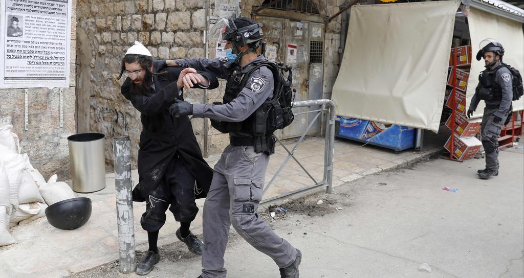 Israeli security forces arrest an Ultra Orthodox Jewish man as they close a synagogue in the Mea Shearim Ultra-Orthodox neighbourhood in Jerusalem, amid efforts to curb the spread of the COVID-19 coronavirus pandemic.