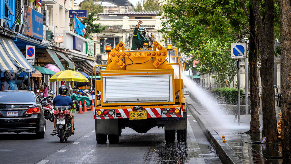 Workers disinfecting the streets of Bangkok amid the COVID pandemic 