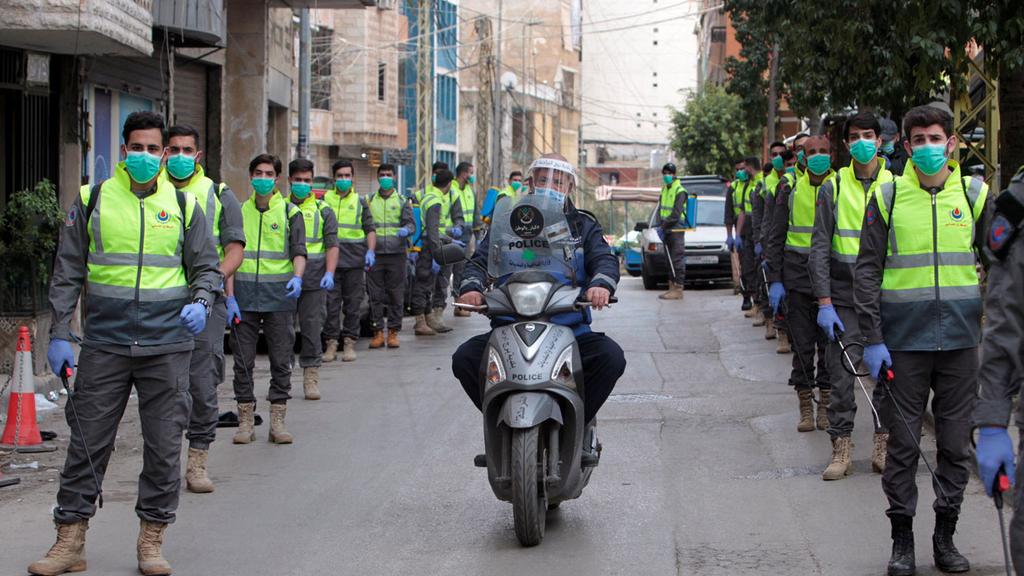 Hezbollah operatives spraying disinfection on the streets of Lebanon during the coronavirus pandemic 