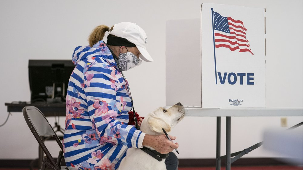 Catherine Anderson sits with her dog, Ivy, as she votes in the Wisconsin Primary 