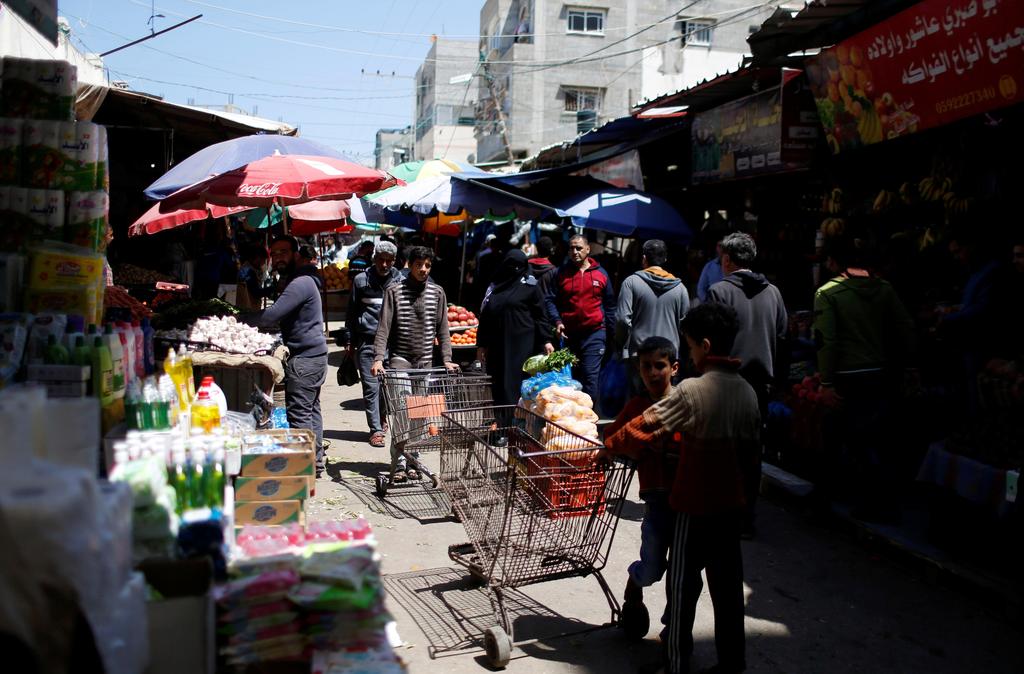 Palestinians shop in a Gaza market amid concerns over the spread of coronavirus